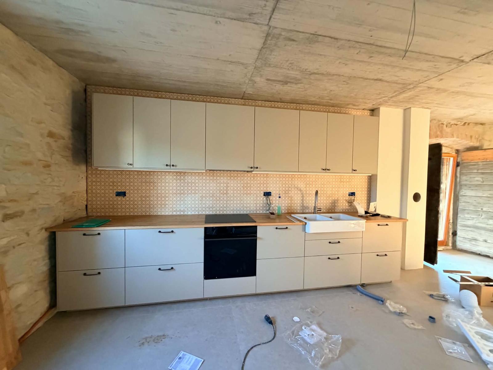 Beige kuhinja z lesenim pultom